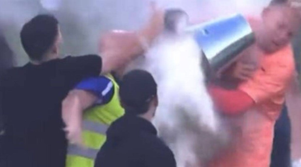 ફૂટબોલ મેચ દરમિયાન એક દર્શકે ટોમ ગ્લોવર પર સફેદ પદાર્થથી ભરેલી લોખંડની ડોલ ફેંકીને મારી હતી  (Screengrab: Paramount plus)